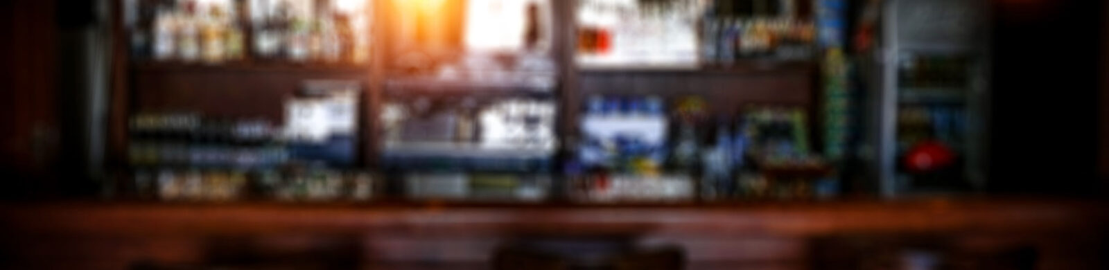 blurry bar counter with alcohol in background