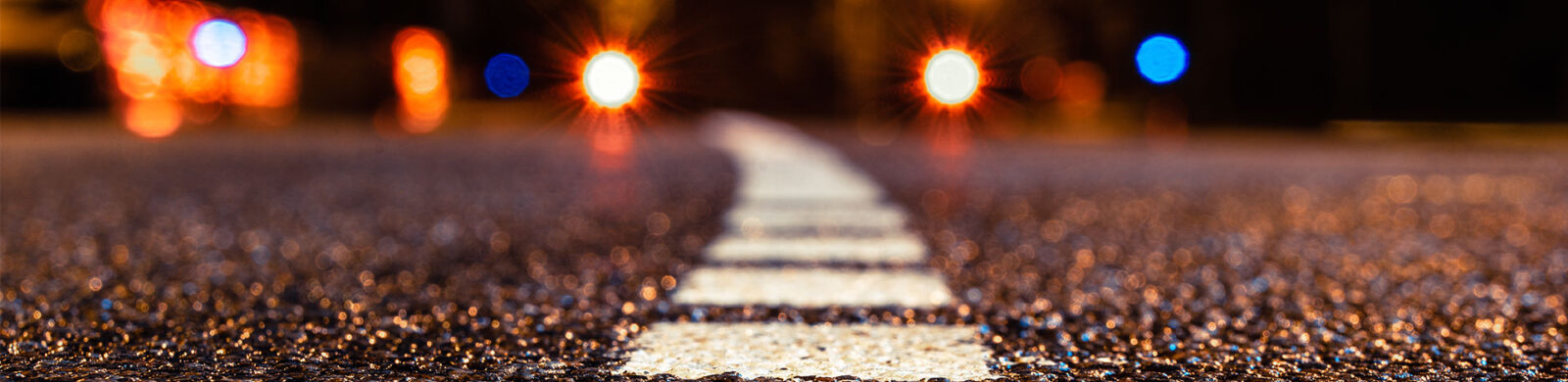 highway at night with emergency lights in the distance