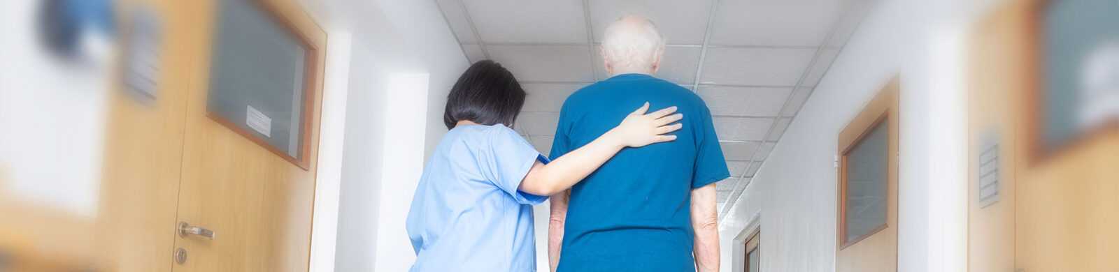 blurred nurse and patient walking down a hallway